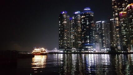 Busan, Korea. Skyscrapers and boat at night.