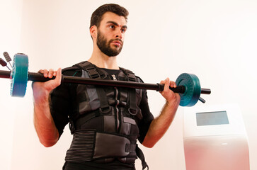 Fototapeta na wymiar Man lifting weights in EMS gym