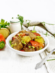 Meat with oranges in bowl on table