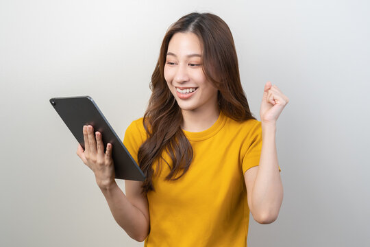Portrait of face expression smile charming brunette, happy asian young woman, girl hand holding tablet, touchpad looking on screen, application in social network online on communication of technology.