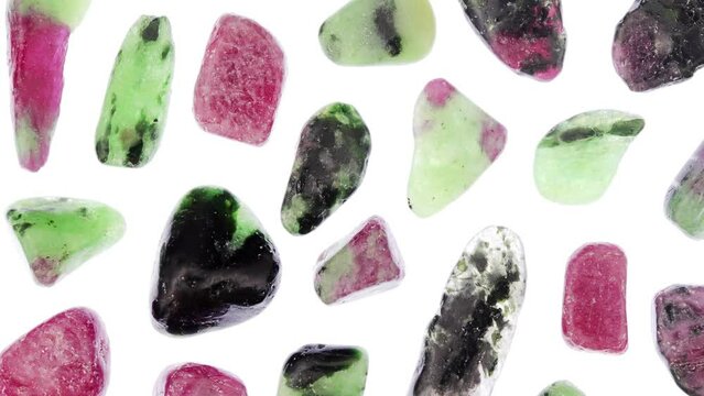 Ruby zoisite rare jewel stones texture on light white surface background. Moving right seamless loop backdrop.