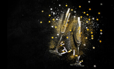 Two glasses of champagne with glitter and splash. Celebration theme.