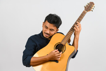 Obraz premium Portrait of Young Asian man playing an acoustic guitar isolated on white background