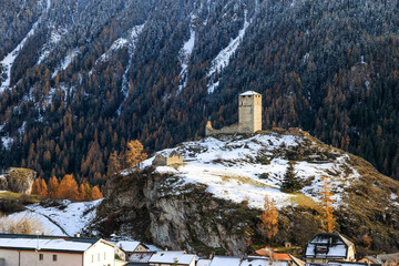 Ruins Steinsberg from the ancient Medieval Castle Steinsberg over the Swiss Alp village Ardez with snow mountain at the background in Engadin valley, Graubunden Canton