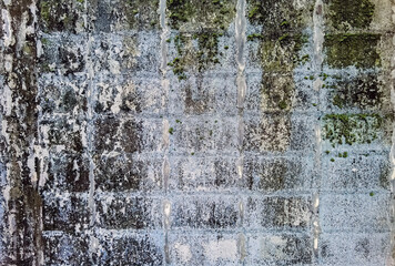 Dirty old eroded cracked plaster cement block fence. Concrete block wall. Destroyed crumbling cement mortar texture. Background of wall. Brick texture with scratches and cracks. brick wall background