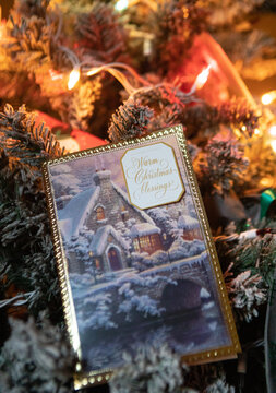 Christmas card on Christmas tree with lights in background