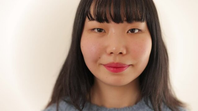 Beautiful asian woman's smile face. Close-up. Slow-mo.