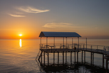 pier with gazebo on the water during dawn on the lake