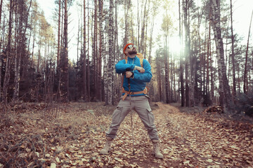 Obraz premium autumn camping in the forest, a male traveler is walking through the forest, yellow leaves landscape in October.