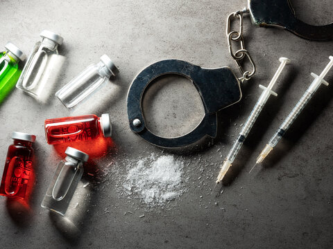 Handcuffs and syringes and drug powder