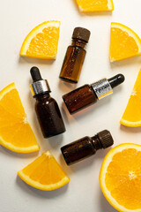 Essential orange oil in a bottle, pieces of fresh fruit. Natural flavors. Citrus oil for skin care, spa, wellness, massage, aromatherapy and natural medicine. Selective focus.