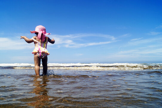 nena caminando en la playa