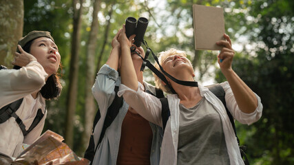 happy women enjoying nature travel.female traveler carrying a backpack.Hiking tourists use maps to travel.woman using binoculars to look at nature in the mountains.