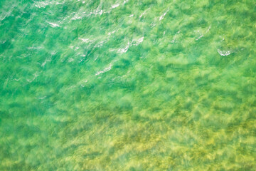 Aerial view of sea surface water texture background and sun reflections Aerial flying drone view Waves water surface texture on sunny tropical ocean in Phuket island Thailand