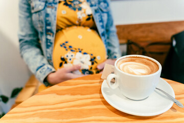 Drink coffee pregnant woman. Happy pregnancy girl drink hot coffee in restaurant. Represent breakfast for energy and freshness concept.