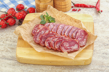 Sliced salami sausages over board