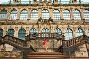 Saxon architecture in Dresden. Saxon Palace Zwinger. Girl posing on the stairs in front of the...