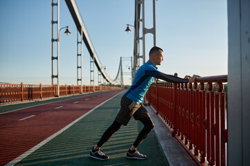 Man runner doing stretching workout before running marathon