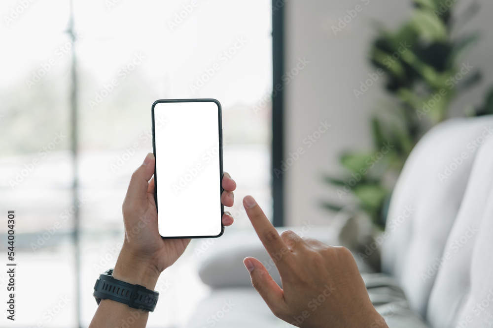Poster Man's hands holding a smartphone with a white blank display, an empty screen for a social media app ad at home. Mobile application technology concept, text message, or information content.
