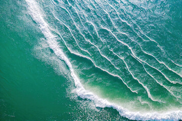 Fototapeta na wymiar Top view of waves breaking on a beach, water splits the composition in half, tropical island, Beautiful Beach Sand Landscape Copyspace Background.