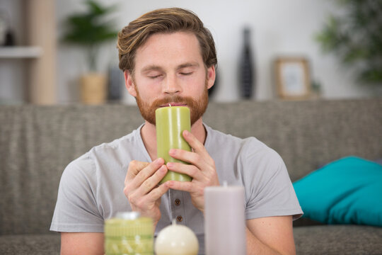 Man Smelling A Scented Candle