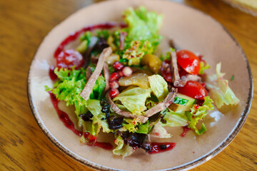 plate with salad with meat, vegetables and red sauce. 