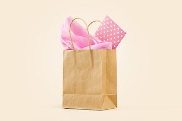 Gift or Sale concept. Shopping buff paper bag, with pink tissue. Polka dot gift card. Copy space....
