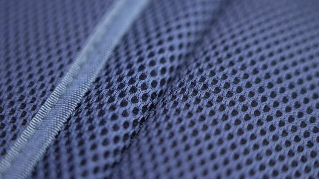 Blue synthetic nylon mesh surface with a smooth seam. Close-up. Rotation