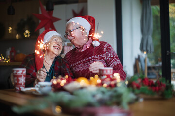 Happy senior couple celebrating Christmas Eve with sparklers.