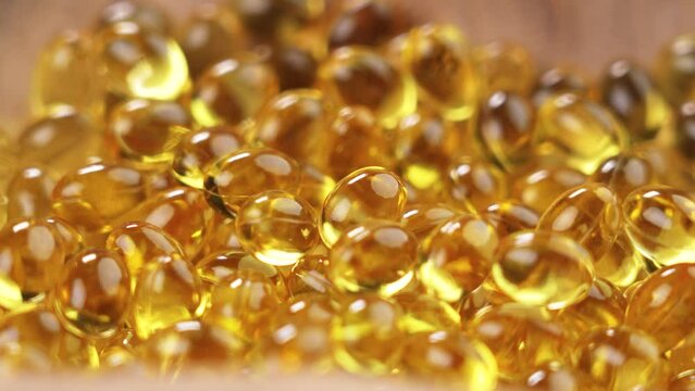 Omega 3 translucent golden capsules. Dietary nutritional supplements. Polyunsaturated fatty acids yellow pills. Macro. Rotation