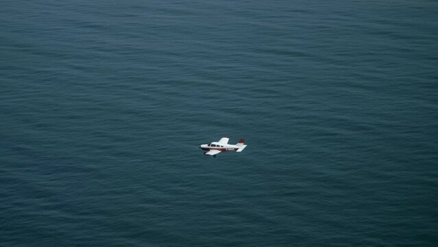 Light Private Single Engine Airplane Flying Above the Sea, Air to Air.