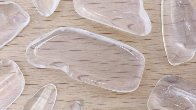 Clear quartz rare jewel on varnished light wood texture. Moving right seamless loop backdrop.