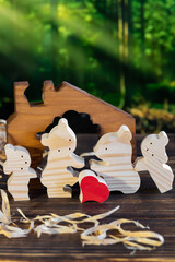 Wooden puzzle in the form of a family of handmade bears on the background of the forest