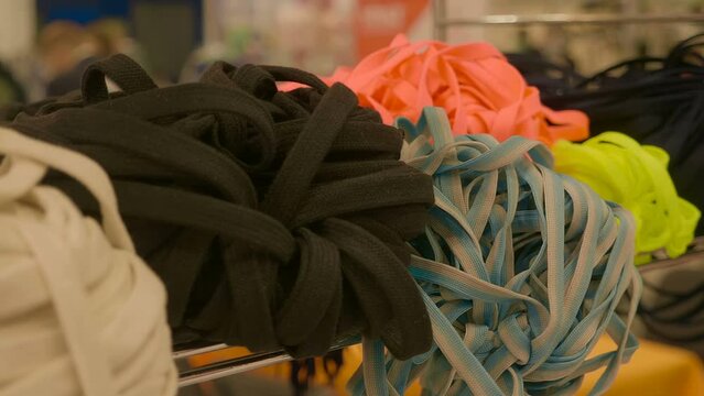 Large bundles with ropes, laces of different colors on the counter in the store. Shot in motion. Macro. Closeup