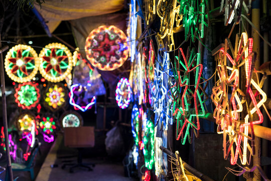 Parols for sale at a stand at nighttime. A Filipino ornamental lantern displayed during the Christmas season.