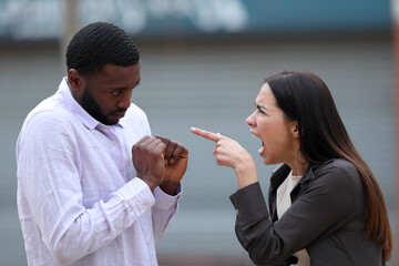 Woman scolding to a black man in the street