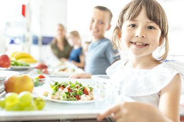 Smiling student with healthy lunch at school cafeteria