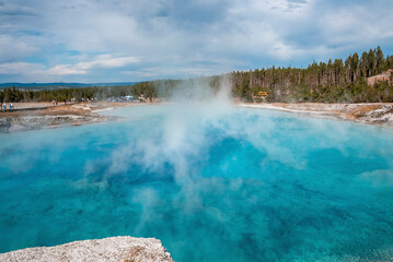 Scenic view of smoke emitting from Excelsior Geyser amidst geothermal landscape. Erupted hot spring...