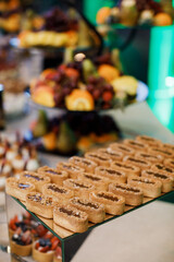 Chocolate caramel tart with nuts in a white plate on a wooden background