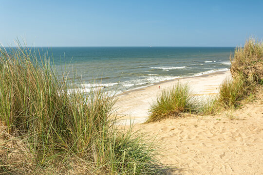 View of the beach and ocean through the dunes on the island of Sylt in Northern Germany