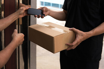 Closeup woman client pick up post express parcel from fast Delivery man black shirt carrying...