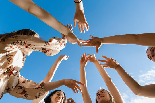 Friends dancing under blue sky