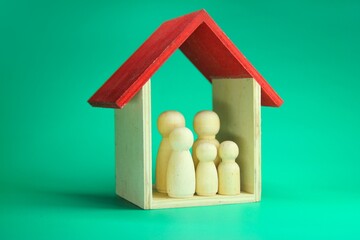 a family of wooden statues in the house. Family care concept, protection and insurance concept.