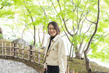 日本庭園を散策しながら写真を撮る女性