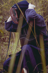 kendoka man in the forest dressing up his uniform. Kendo is the Japanese martial art of sword fighting