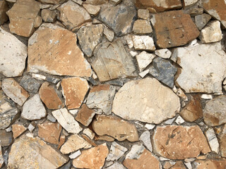 Old ancient wall with different stones as abstract background