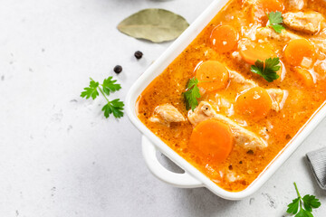 Pork carrot goulash in ceramic dish. Top view, copy space, flat lay.