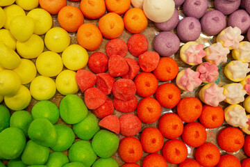 Texture of red, yellow, orange and green marshmallows laid out on a tray