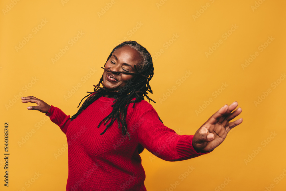 Wall mural Joyful black woman dancing in a studio