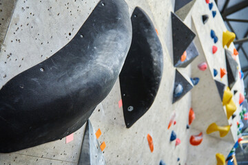 Wall for bouldering in gym with holds for climbing. Active extreme sport concept © Lazy_Bear